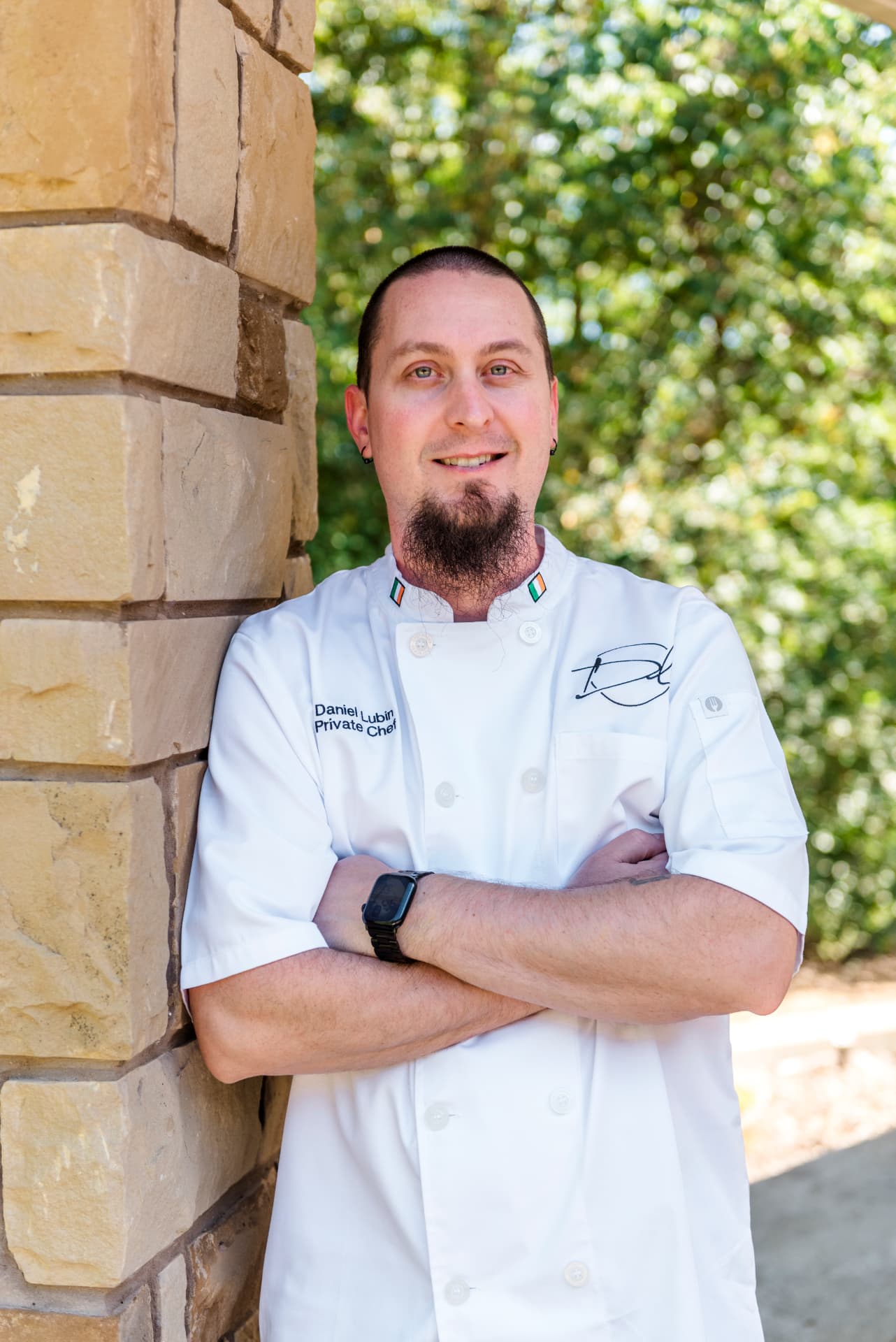 Chef Daniel Lubin in white chef whites with his signature embroidered on the jacket
